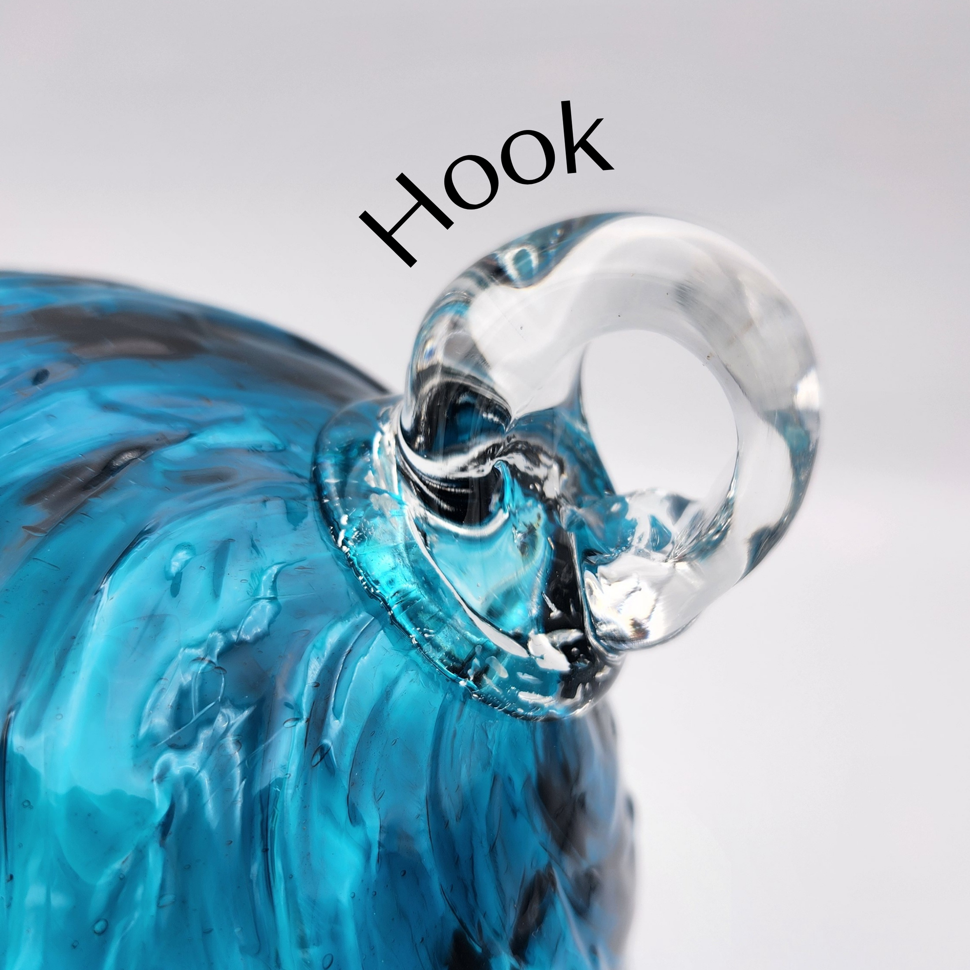 a close up photo of a glass hook attached to a blown glass ornament.